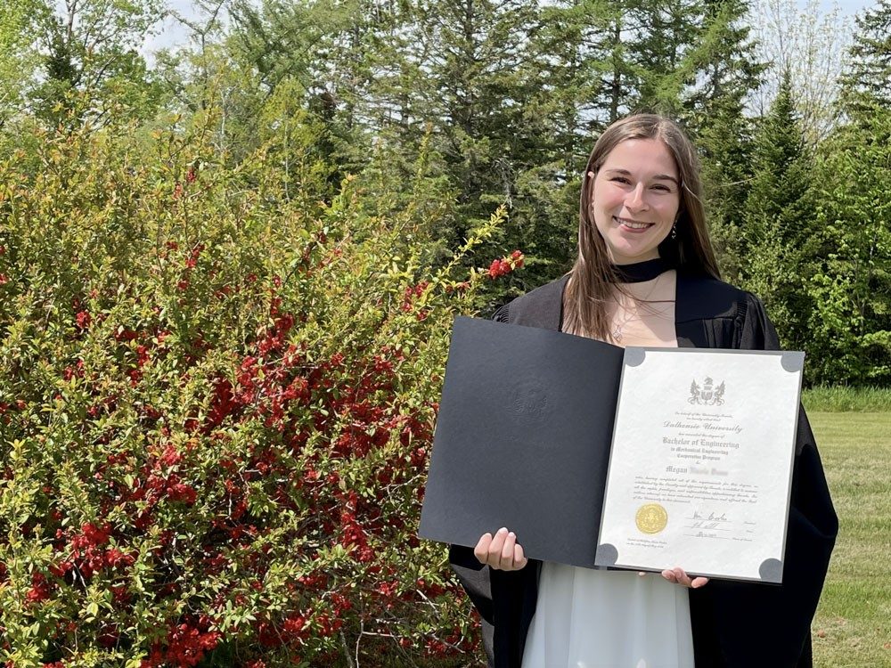 Megan holding her graduate certificate